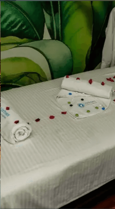 Lintons spa treatment table with branded towels and rose petals